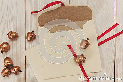 Christmas background.Open envelope with golden acorns.White wooden table.Empty space Stock Photo