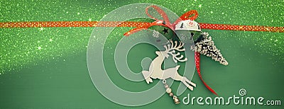 Christmas background with red silk traditional ribbon, white deer, evergreen tree and jingle bells. Stock Photo