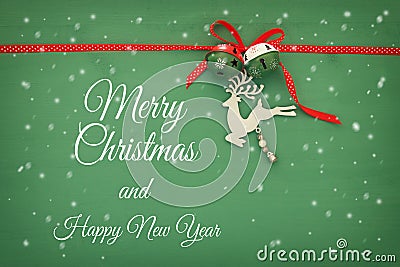 Christmas background with red silk traditional ribbon, white deer and jingle bells. Stock Photo