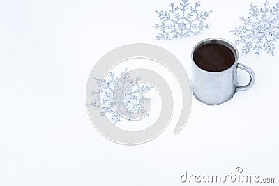 Christmas background with snowflakes and a mug of hot coffee in the snow. Snowflakes around an old metal mug with a coffee drink Stock Photo
