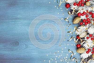 Christmas background with snowy fir tree and holiday decorations on blue wooden table top view. Greeting card with space for text. Stock Photo