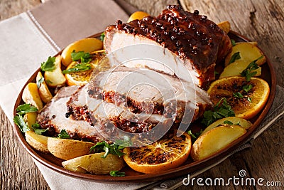 Christmas baked ham chopped slicesï¿½with potatoes, oranges and ap Stock Photo