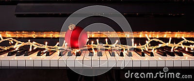 Christmas ball and lights on a piano keyboard, front view Stock Photo