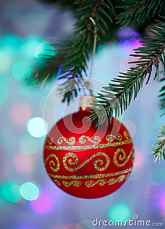 Christmas ball with ornament hanging on xmas tree, defocused lights Stock Photo