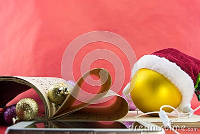 Christmas ball with Santa's hat and earphones, music notation book with pages shaping heart Stock Photo