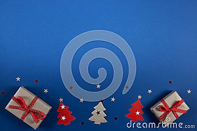 Christmas banner with gift boxes, Xmas tree, snowflakes and stars handmade on blue background with copy space. Stock Photo