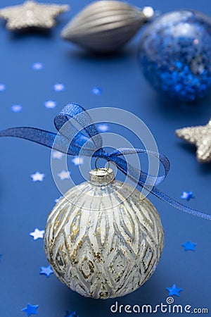 Christmas bauble with blue ribbon over blue background. Winter holidays greeting card. Classic blue Stock Photo