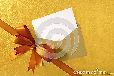 Christmas or birthday card, diagonal gold gift ribbon bow, blank card and envelope, copy space Stock Photo