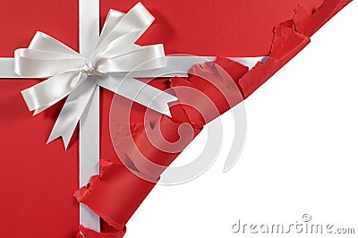 Christmas or birthday white satin gift ribbon bow on torn open red paper background Stock Photo