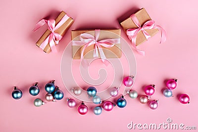 Christmas border with gift boxes, balls, decoration and sequins on pink table top view. Stock Photo