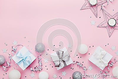 Christmas border with gift boxes, balls, decoration and sequins on pink table top view. Flat lay. Copy space for greeting card. Stock Photo