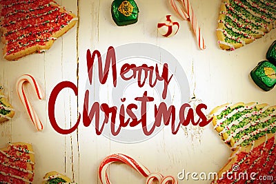 Christmas border of sweets, including cookies, peppermints and chocolates on a rustic wooden background. Stock Photo