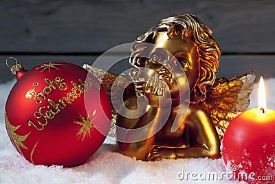 Christmas bulb burning candle golden putto on pile of snow Stock Photo