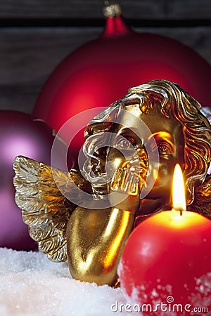 Christmas bulbs burning candle golden putto on pile of snow Stock Photo