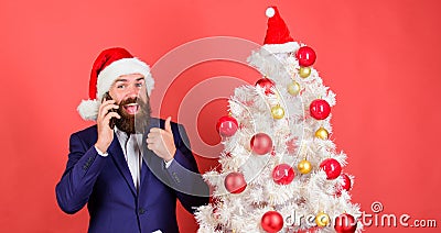 Christmas call. Create santa call this christmas. Man bearded wear suit and santa hat hold phone. Manager congratulate Stock Photo