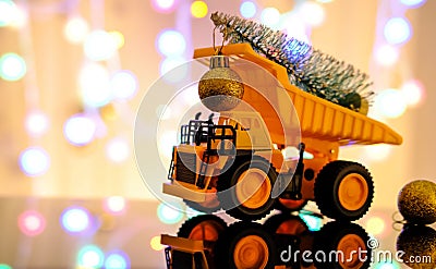 Christmas card. Children`s truck carries a Christmas tree. Bokeh, multicolor color. Light blurred background Stock Photo