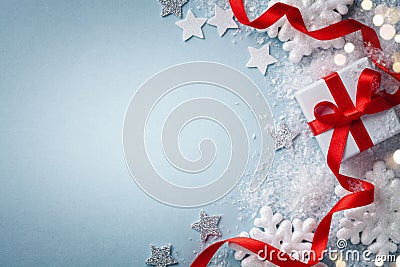 Christmas card. Gift or present box with red ribbon and holiday decoration on blue background top view. Happy New Year composition Stock Photo