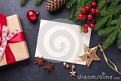 Christmas card with paper, gift box and fir tree branch on stone background. Holiday mockup. Top view Stock Photo