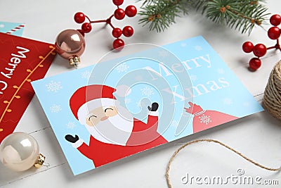 Christmas cards and festive decor on white wooden background Stock Photo