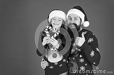 Christmas Carol. Father and daughter with candy canes christmas decorations. Family holiday. Santa claus family look Stock Photo