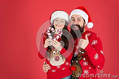 Christmas Carol. Father and daughter with candy canes christmas decorations. Family holiday. Santa claus family look Stock Photo