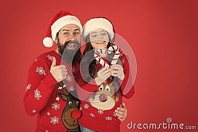 Christmas Carol. Father and daughter with candy canes christmas decorations. Family holiday. Santa claus family look Stock Photo