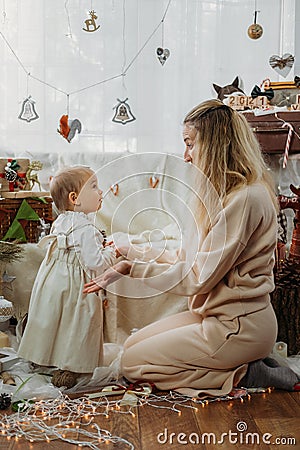 Christmas celebration at home in new normal. Family celebrating Christmas in time of COVID pandemic. Mom and baby Stock Photo