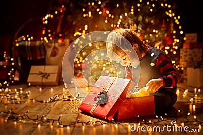 Christmas Child Open Present Gift, Happy Baby Boy looking Box Stock Photo