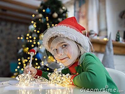 Christmas child writes a letter to Santa while sitting at the table against a bokeh background Stock Photo