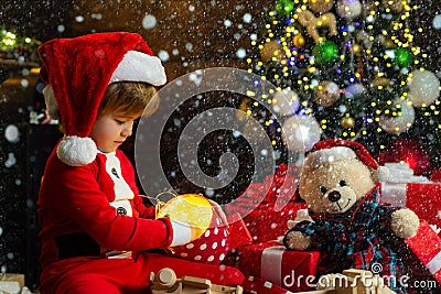 Christmas childs in snow. Boy child play near christmas tree. Merry and bright christmas. Childhood activity and game Stock Photo