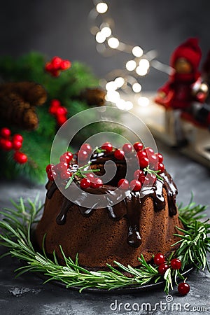Christmas, New Year, Xmas or Noel chocolate bundt cake with glaze decorated with fresh berries and rosemary Stock Photo