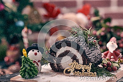 Christmas chocolate roll cake placing together with snowman Stock Photo