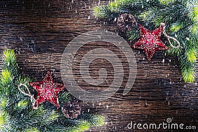 Christmas. Christmas fir tree with star and pine cone on rustic wooden table. Diagonally composition border in snowy atmosphere Stock Photo