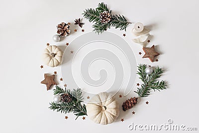 Christmas circle floral composition. Wreath of fir tree branches, pine cones, confetti, wooden stars, white pumkins on Stock Photo