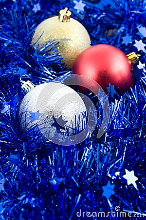 Christmas colored balls in blue tinsel Stock Photo