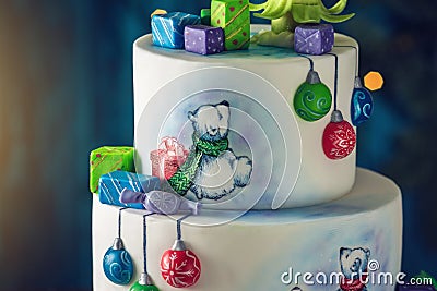 Christmas colorful three-Tiered cake decorated with drawings of Teddy bears, gift boxes and a green tree top Stock Photo