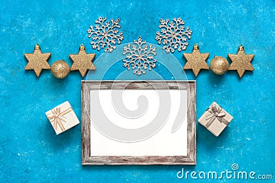 Christmas composition. Blank photo frame mockup, gift boxes, golden stars, balls and snowflakes. Turquoise blue grunge background Stock Photo