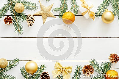 Christmas composition. Christmas frame with golden decorations, ornaments, balls, stars, gifts, pine cones, bow on wooden white Stock Photo