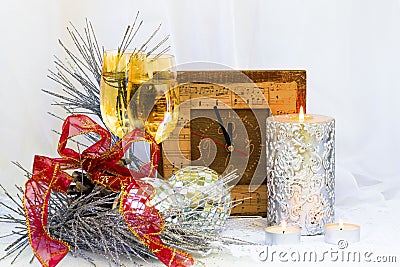 Christmas composition with clock, glasses and a thick silver candle... Stock Photo