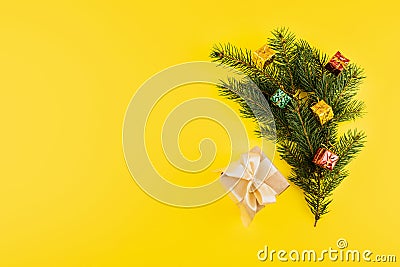 Christmas composition with Conifer Evergreen tree branches and gift box on yellow background. Christmas and 2020 new year minimal Stock Photo