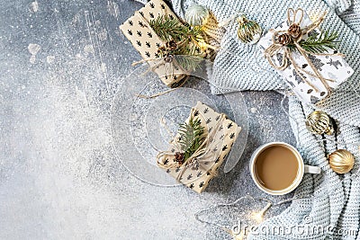 Christmas composition with cup of coffee, knitted blanket, garland and gift on a gray background. Winter, Christmas concept. Flat Stock Photo