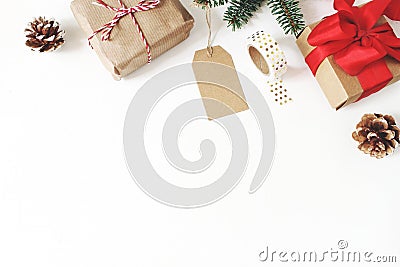 Christmas composition. Frame of fir tree branches, pine cones, christmas gift boxes, tag, golden washi tape, ribbons on Stock Photo