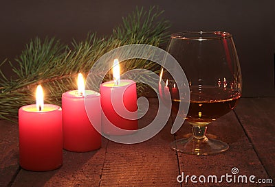 Christmas Composition with glass cognac, Gift box and candle on wooden table Stock Photo