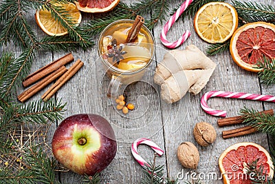 Christmas composition. Spruce branches, candy cane, warming tea with ginger and lemon, dried oranges, Stock Photo
