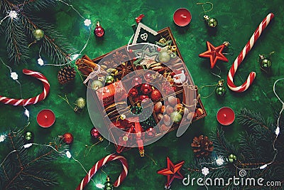Christmas composition. Christmas tree and box with spices and toys on green wooden background Stock Photo