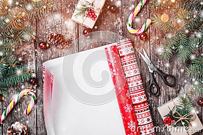 Christmas composition with xmas wrapping, Fir branches, gifts, pine cones, red decorations on wooden background. Stock Photo