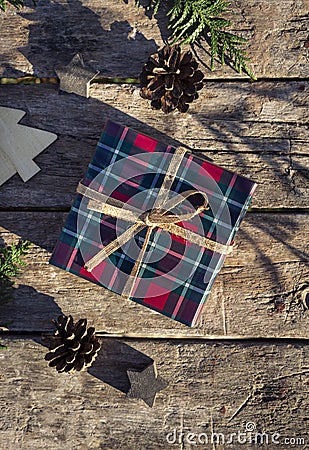 Christmas concept composition with tartan pattern gift box on the old weathered wooden table. Winter holiday greeting card Stock Photo