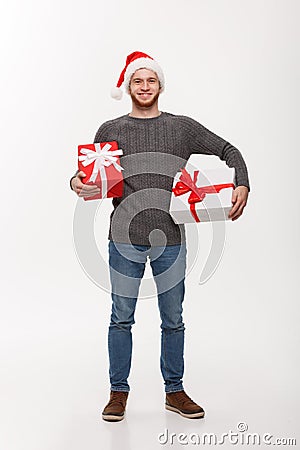 Christmas Concept - Happy young man with beard carries a lot of presents isolated on white background. Stock Photo