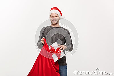 Christmas Concept - Young happy beard man excite with big present in santa bag. Stock Photo