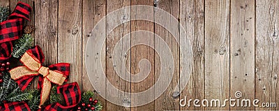 Christmas corner border banner with red and black checked buffalo plaid ribbon, burlap and branches, top view on a wood background Stock Photo